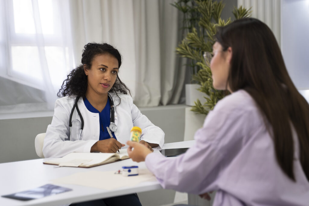 Doctor discussing risks and safety considerations of breast reduction surgery with a patient during a consultation.