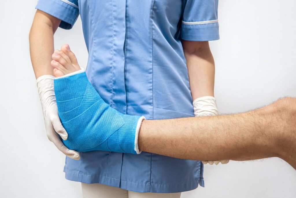 Advanced trauma reconstruction surgery for severe injuries showing a healthcare professional supporting a patient with a leg cast during recovery and rehabilitation after complex traumatic injury treatment.