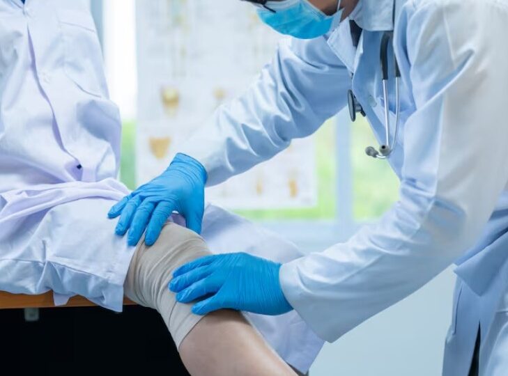 Treatment for severe accident injuries showing a healthcare professional assessing and managing a leg injury as part of recovery and rehabilitation care.